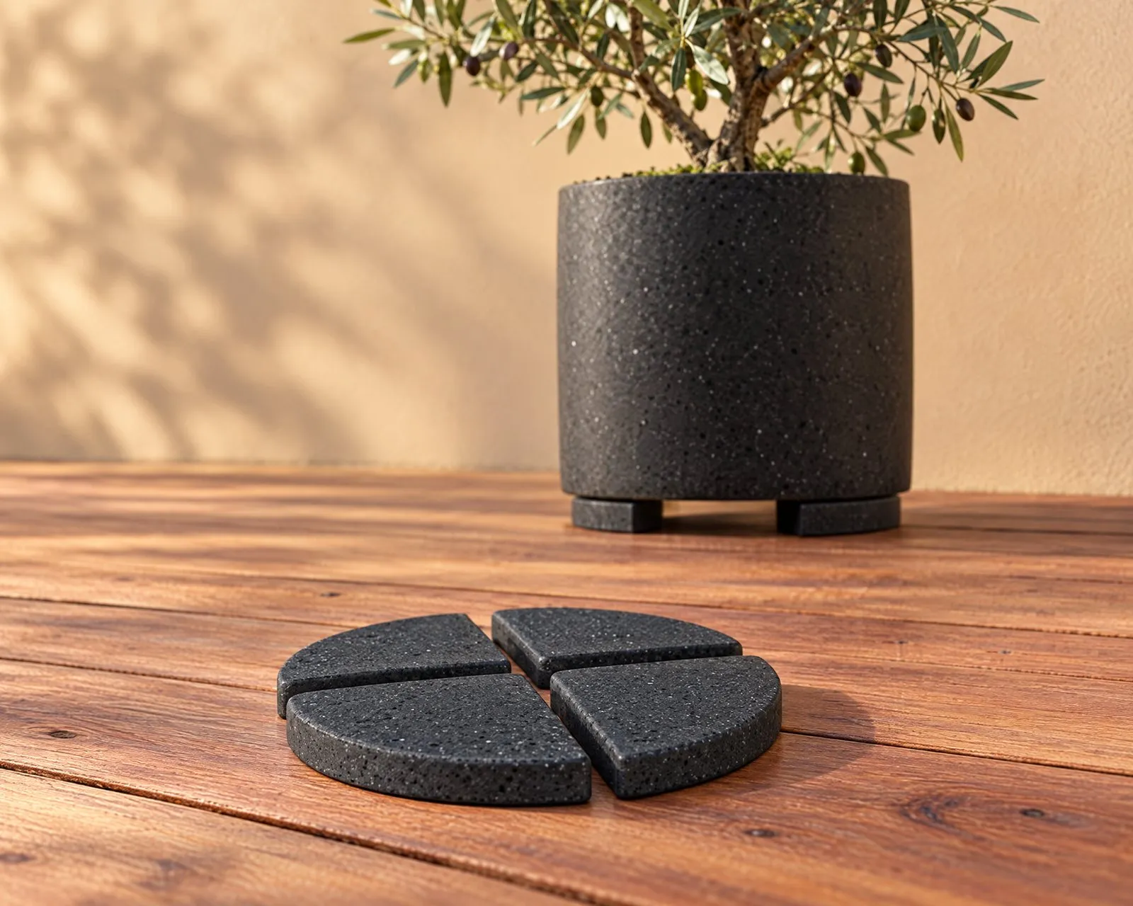 Four Onyx pot feet on a deck, with a pot raised on another set behind
